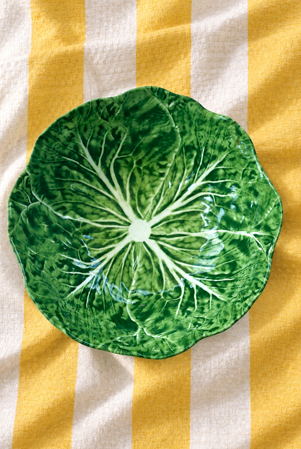 Green Medium Bowl – Cabbage Melamine on yellow and white striped tablecloth