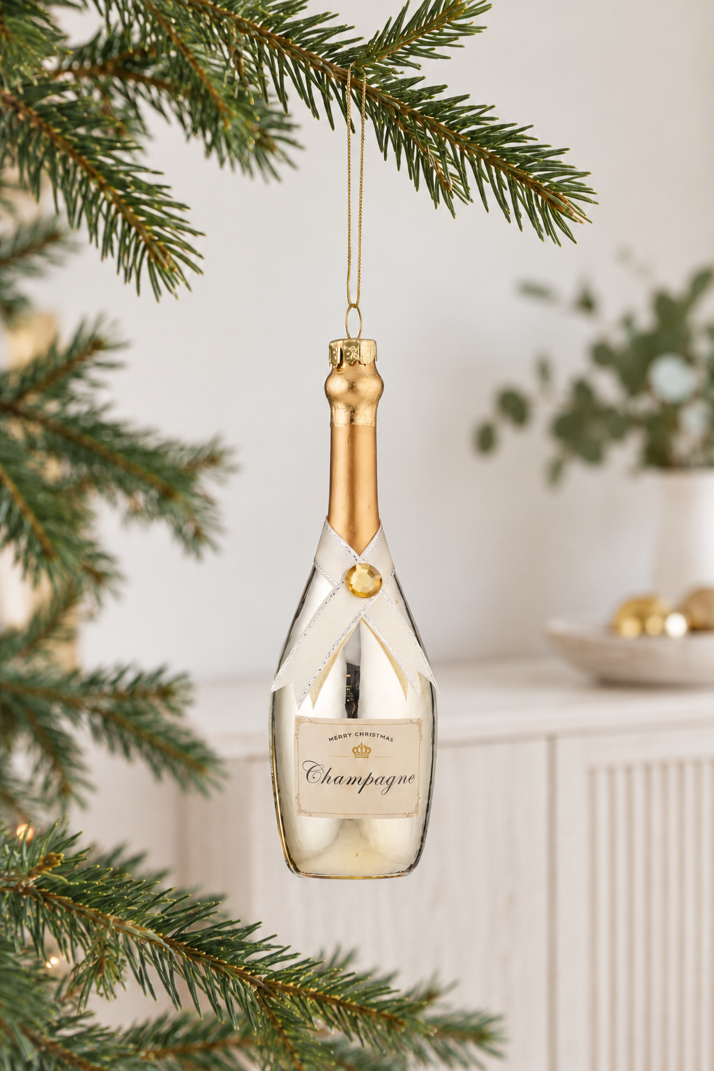 Champagne Glass Ornament - Gold styled indoors with pale whitewashed furniture and summer light; Coast to Coast XM0552