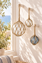Clear and grey buoy glass floats with rope in a coastal interior