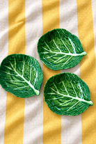 Green Stemmed Dish Small – Cabbage Melamine on yellow and white striped tablecloth