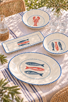 Nautical melamine serveware collection styled on a sunlit coastal table